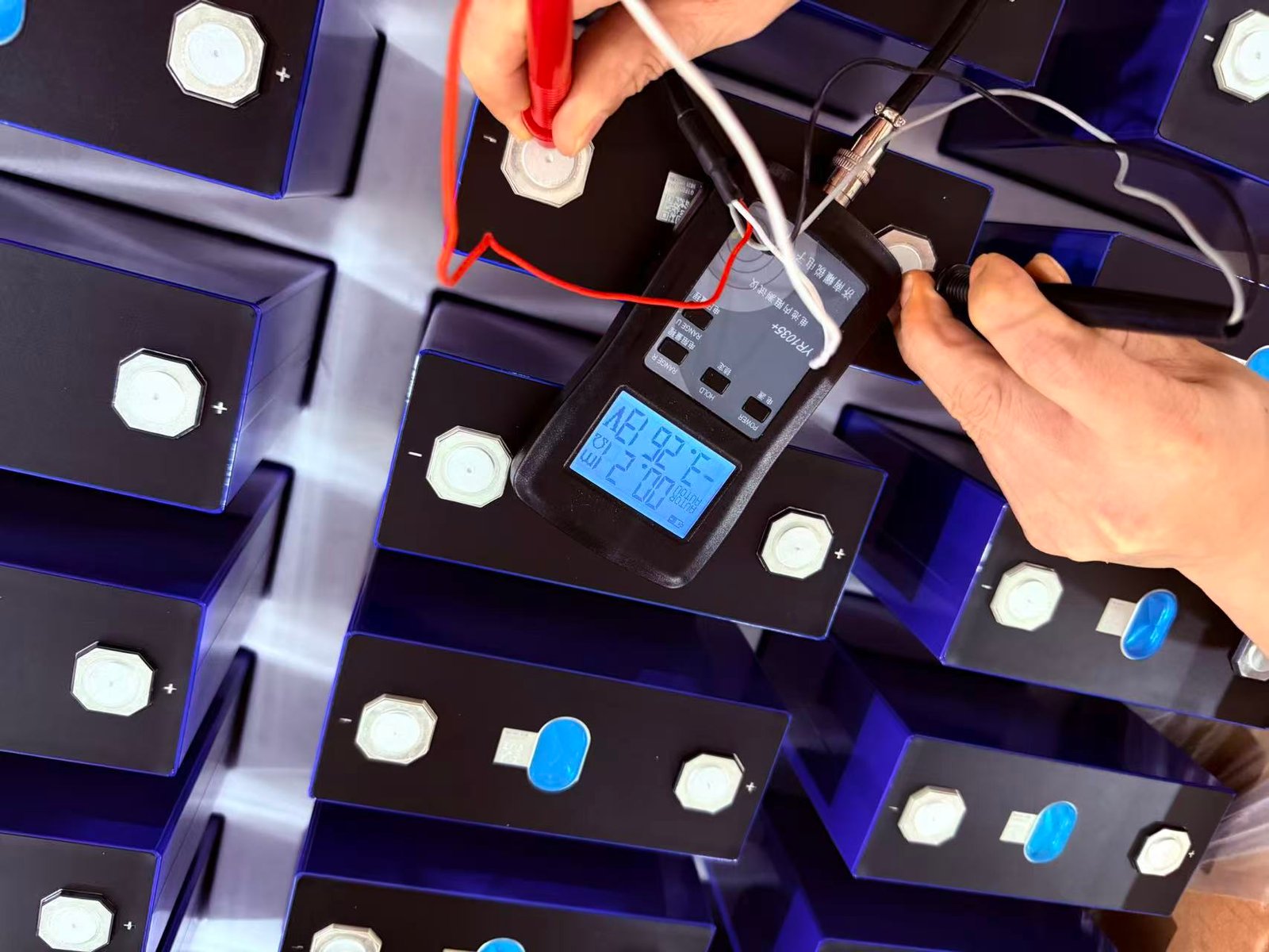 Operator taking an in-process reading on a prismatic battery cell